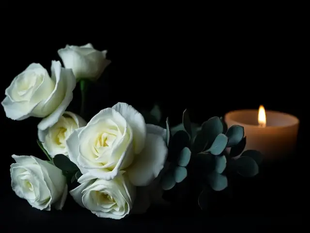 Rose bianche ed eucalipto alla luce di una candela